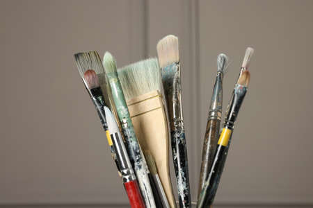 Set of different paintbrushes on gray background, closeup
