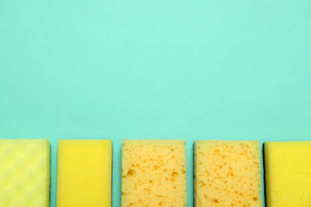 Many sponges on turquoise background, flat lay. Space for textの写真素材