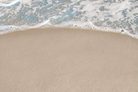Beautiful foamy sea tide on sandy beach