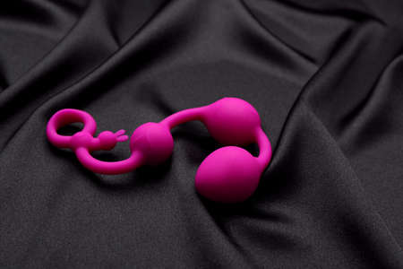 Pink anal balls on black fabric. sex toyの写真素材