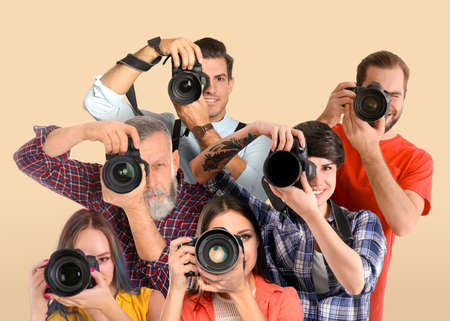 Group of professional photographers with cameras on beige backgroundの写真素材