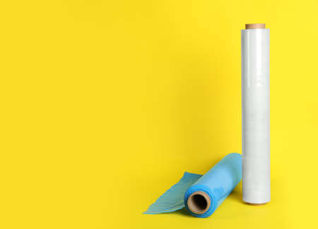 Rolls of different stretch wrap on yellow background. Space for textの写真素材