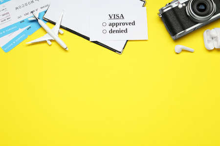 Flat lay composition with passport, toy plane and tickets on yellow background, space for text. Visa...