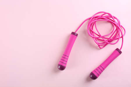 Skipping rope on pink background, top view. Space for textの写真素材