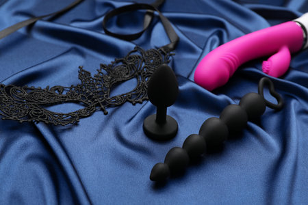Sex toys and black lace mask on blue silky fabricの写真素材