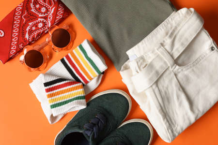 Stylish child clothes, shoes and accessories on orange background, flat layの写真素材