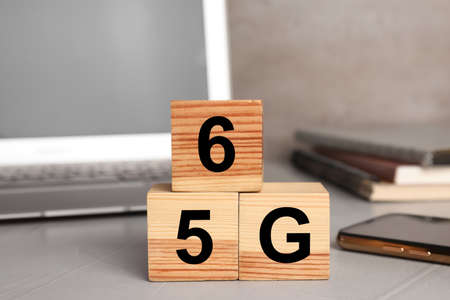 5G and 6G technology, Internet concept. Wooden cubes on light office table, closeup