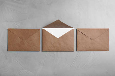Simple brown paper envelopes on light gray table, flat layの写真素材
