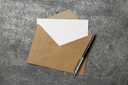Envelope with blank paper card and pen on gray table, top viewの写真素材