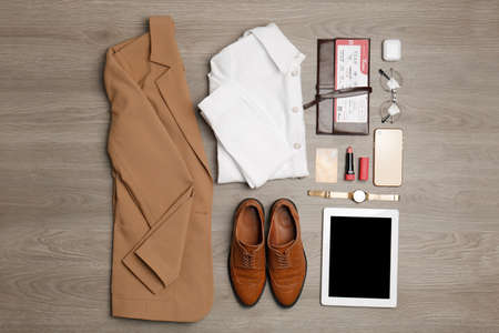 Flat lay composition with clothes, shoes and accessories on wooden background. Packing for business tripの写真素材