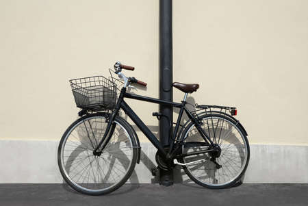 Vintage bicycle with basket locked to street post outdoorsの写真素材