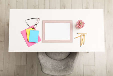 Empty frame and stationery on white table indoors, top viewの写真素材