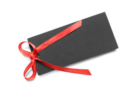 Blank black gift tag with red satin ribbon on white background, top view. space for design