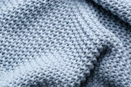 Beautiful light blue knitted fabric as background, closeup