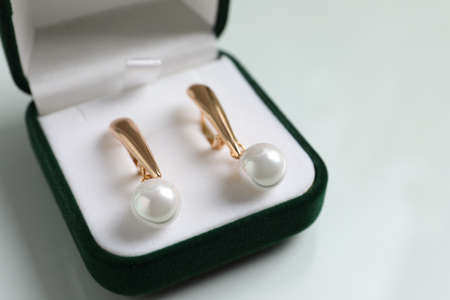 Elegant golden earrings in box on white table, closeupの写真素材