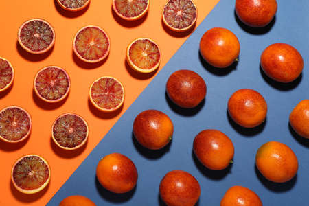 Many ripe sicilian oranges on color background, flat lay