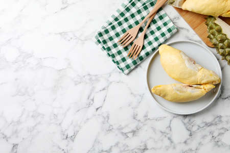 Pieces of fresh ripe durian on white marble table, flat lay. Space for textの写真素材