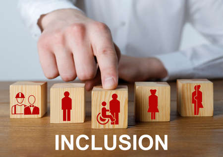 Concept of DEI - Diversity, Equality, Inclusion. Businessman and wooden cubes with images of people on table, closeupの写真素材