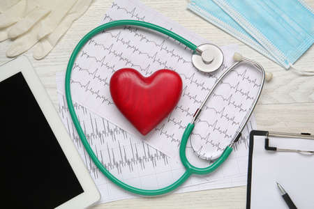 Flat lay composition with stethoscope and red heart on white wooden table. cardiology concept