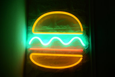 Burger shape neon sign on wall indoorsの写真素材