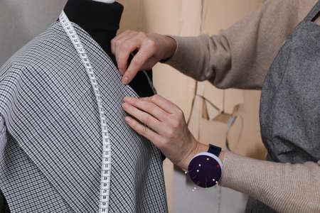 Tailor pinning fabric at mannequin in atelier, closeupの写真素材