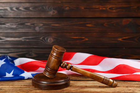 Wooden gavel and American flag on tableの写真素材