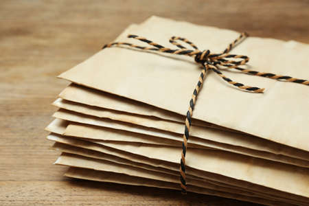 Stack of old letters tied with string on wooden table, closeupの写真素材