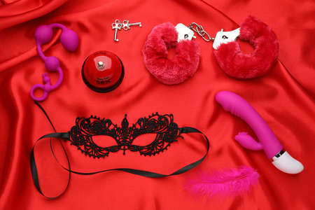 Sex toys and accessories on red fabric, flat layの写真素材
