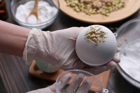 Woman in gloves making bath bomb at table, closeupの写真素材