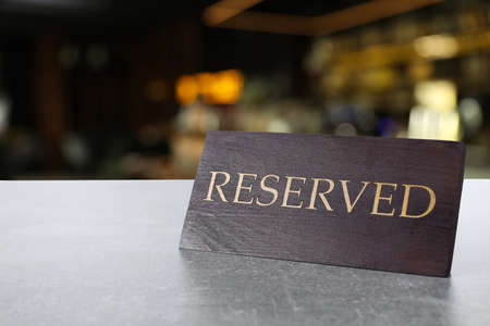 Wooden sign Reserved on gray table in restaurantの写真素材