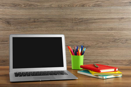Modern laptop and office supplies on wooden table. distance learningの写真素材