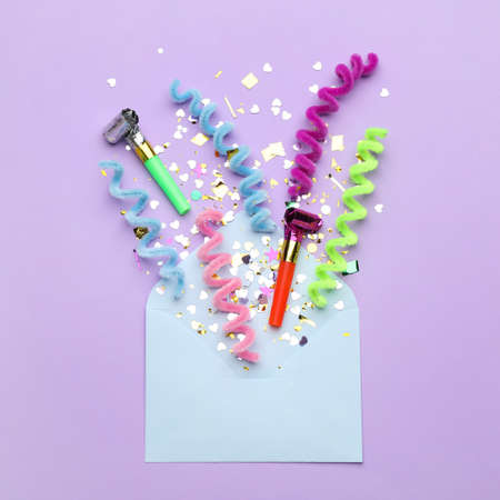 Beautiful flat lay composition with envelope and festive items on violet background. Surprise party...