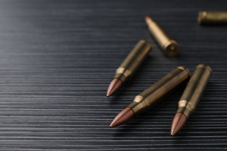 Many bullets on black wooden table, closeup. Space for textの写真素材