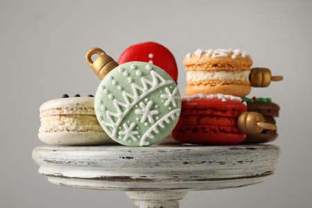 Beautifully decorated Christmas macarons on stand against light gray background, closeupの写真素材