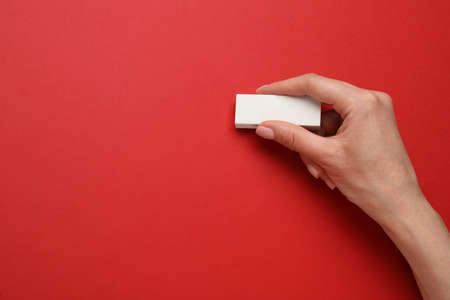 Woman erasing something on red background, closeup. Space for textの写真素材