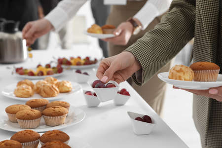 Woman taking snack during coffee break, closeup