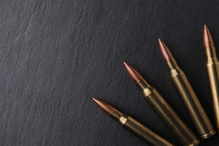 Many bullets on black table, flat lay. Space for textの写真素材