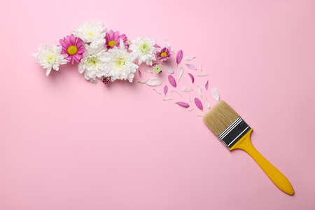 Brush painting with colorful flowers and petals of chrysanthemum on pink background, flat lay. creative conceptの写真素材