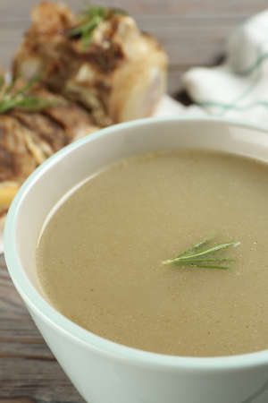 Cup of delicious homemade bone broth on gray wooden table, closeupの写真素材