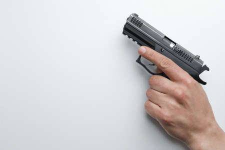 Man holding semi-automatic pistol on white background, closeup. Space for text