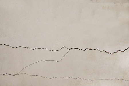 Concrete surface with cracks as background, closeup