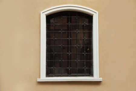 Beautiful arched window with grills in building outdoors