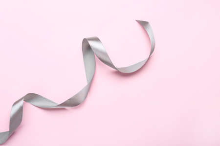 Beautiful ribbon on pink background, top view. Space for textの写真素材