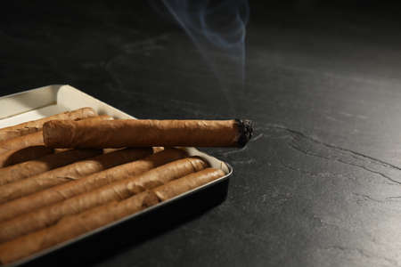 Many cigars in box on black table, closeupの写真素材