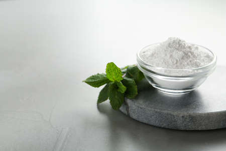 Tooth powder and mint on gray table, closeup. Space for textの写真素材