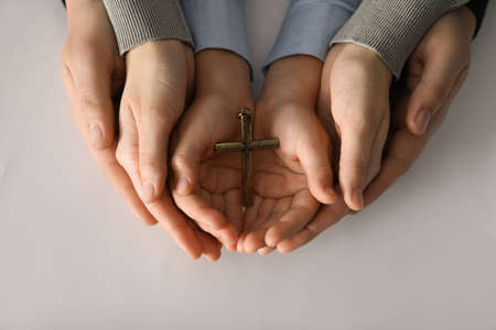 Boy and his godparents holding cross on white background, closeupの写真素材
