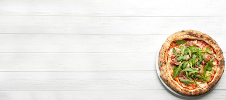Tasty pizza with meat and arugula on white wooden table, top view with space for text. banner designの写真素材