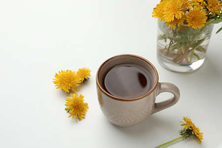 Delicious fresh tea and beautiful dandelion flowers on white backgroundの写真素材