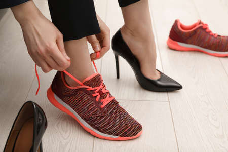 Woman changing shoes in office, closeup view