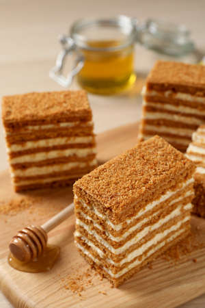Delicious layered honey cake on wooden board, closeupの写真素材